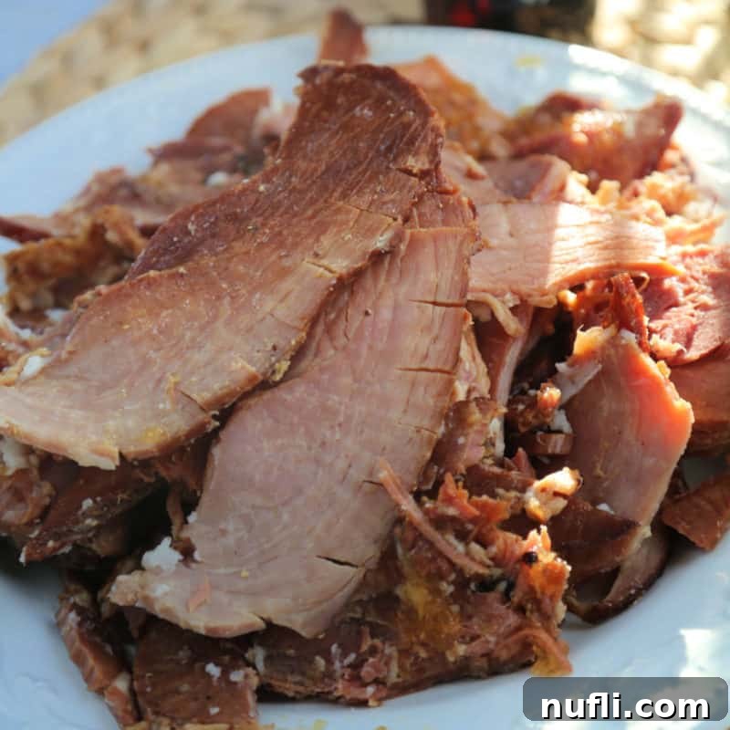slices of crockpot coke ham on a white platter