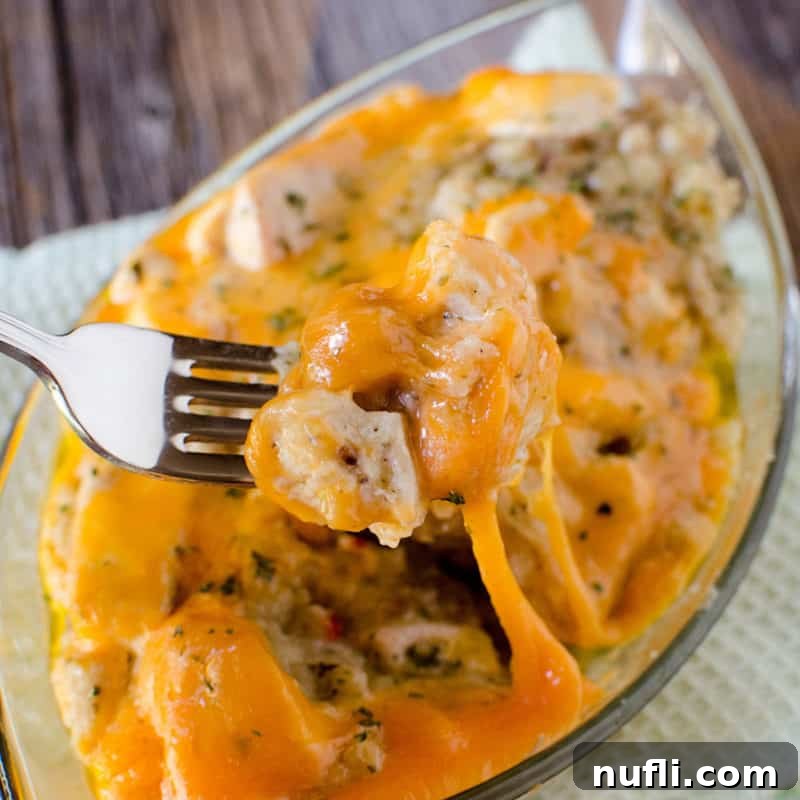 fork holding chicken stuffing casserole over a glass dish