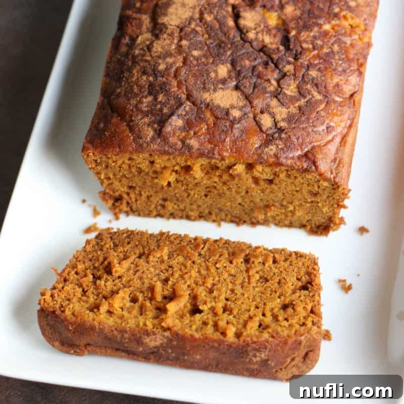 Crockpot Pumpkin Bread with a slice cut on a white platter