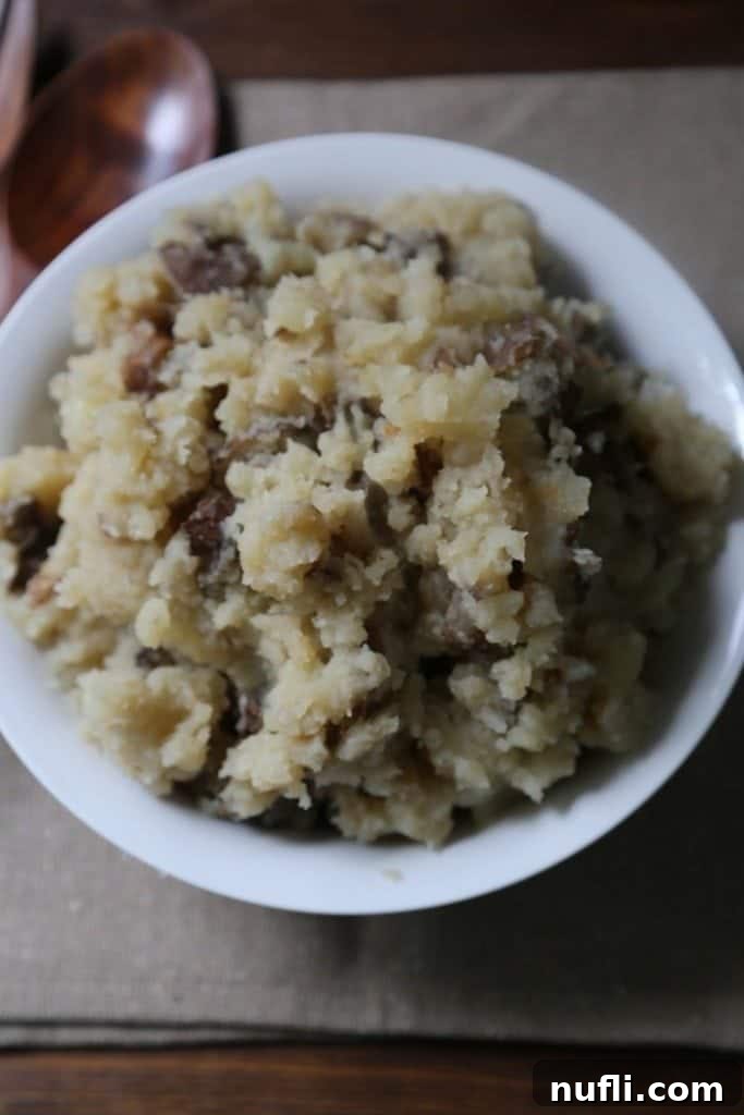 Close up of cooked, tender potatoes in a slow cooker, ready to be mashed into garlic mashed potatoes.