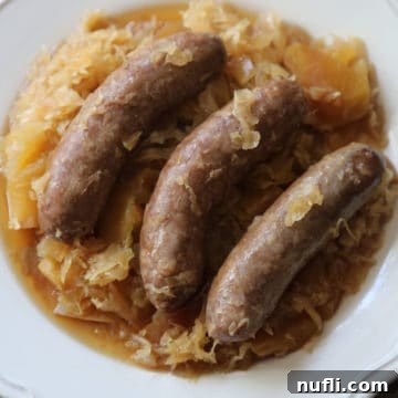 crockpot brats and sauerkraut on a white plate