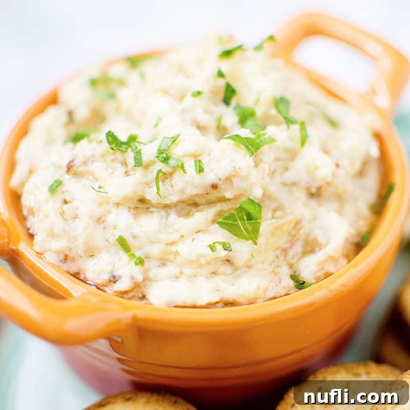 Easy Slow Cooker Appetizers 19 Onion Dip in an orange bowl next to crackers, ready to serve