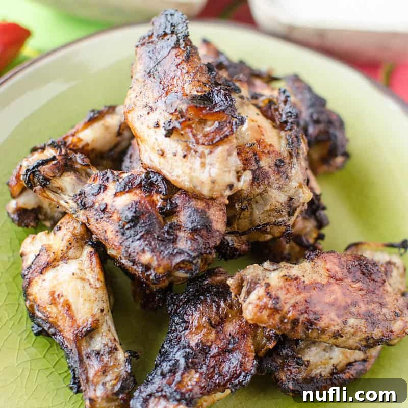 Easy Slow Cooker Appetizers 25 Crock Pot Jamaican Jerk Wings Recipe on a green plate, garnished