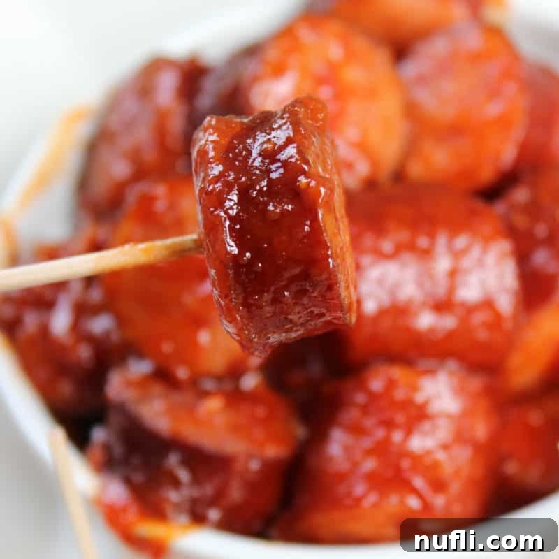 Easy Slow Cooker Appetizers 8 Spicy Barbecue Kielbasa on a toothpick above a bowl, hot and ready