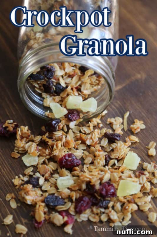 Homemade Crockpot Granola with Sweet Dried Fruit 2 Homemade crockpot granola, golden brown and crunchy, spilling elegantly from a clear mason jar onto a rustic wooden surface, highlighting its delightful texture and rich color.