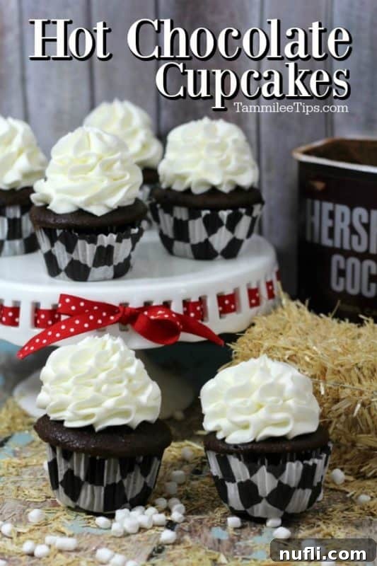 Irresistible Hot Chocolate Cupcakes adorned with marshmallow frosting and cocoa dusting, arranged on a beautiful cake stand.