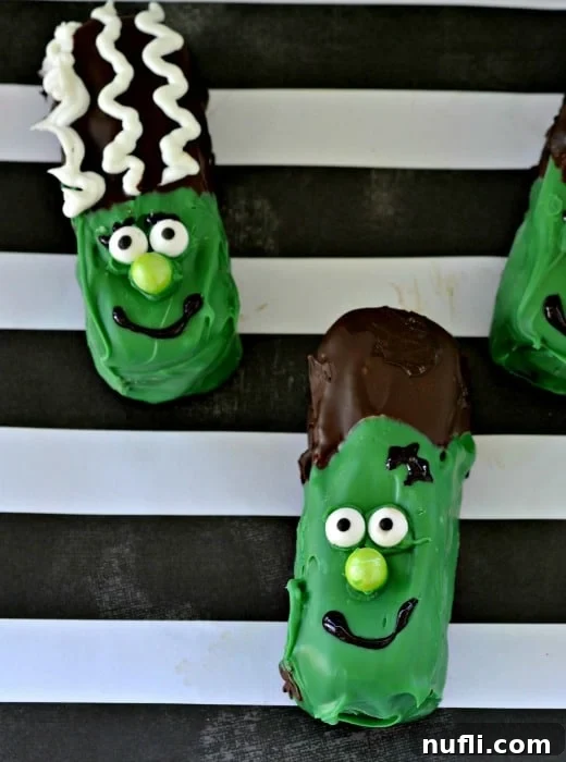Frankenstein Twinkies beautifully arranged on black and white striped paper, perfect for a Halloween display.