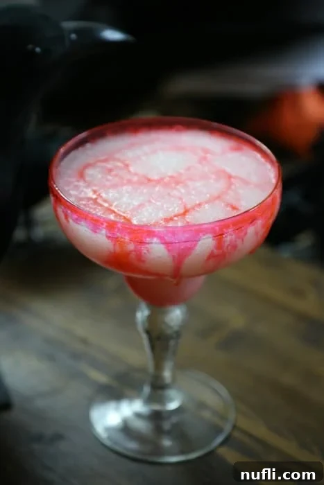 Bloody colada drink in a margarita glass with a crow behind it 