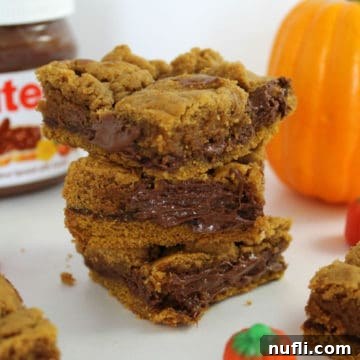 Close-up of a single Pumpkin Nutella Bar next to a jar of Nutella and a decorative pumpkin.