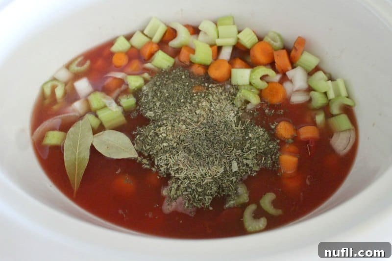 Slow Cooker Magic: Olive Garden Minestrone at Home 4 Diced vegetables and spices in a white slow cooker bowl, ready for cooking.
