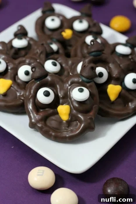 A trio of finished owl pretzels on a white plate, showcasing their adorable design and ready for Halloween enjoyment.