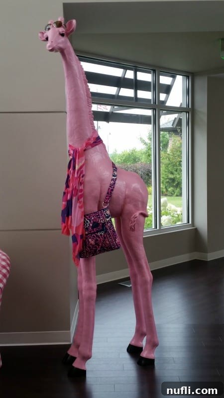 Unveiling Vera Bradley's Creative Heart in Fort Wayne 6 A whimsical pink giraffe sculpture adorned with a stylish Vera Bradley bag, adding a playful touch to the design center