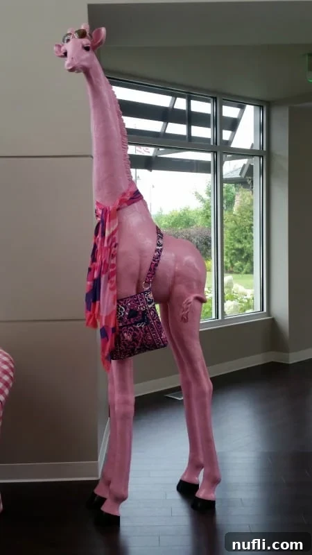 Pink giraffe sculpture wearing a vera bradley bag
