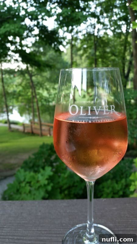 Oliver Winery & Vineyards wine glass with rose on a deck looking out on a post