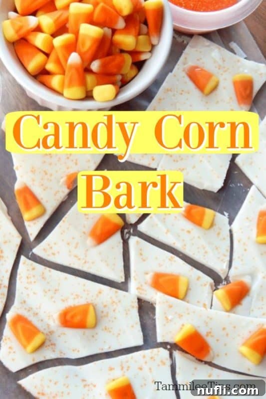 Vibrant Candy Corn Bark pieces next to a bowl of classic candy corn on a rustic surface, perfect for Halloween treats.