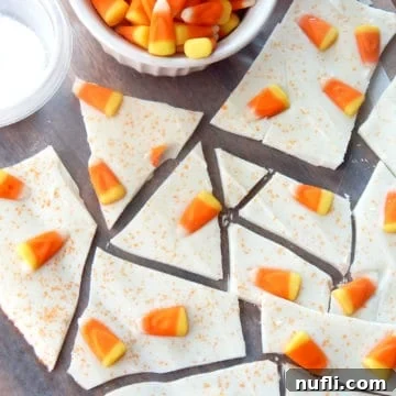 candy corn bark on parchment paper next to a bowl of candy corn