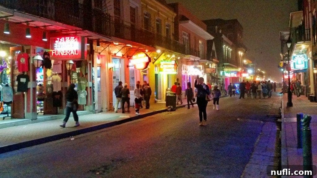 Vibrant night scene captured in the heart of New Orleans' French Quarter, showing lively streets and glowing lights.