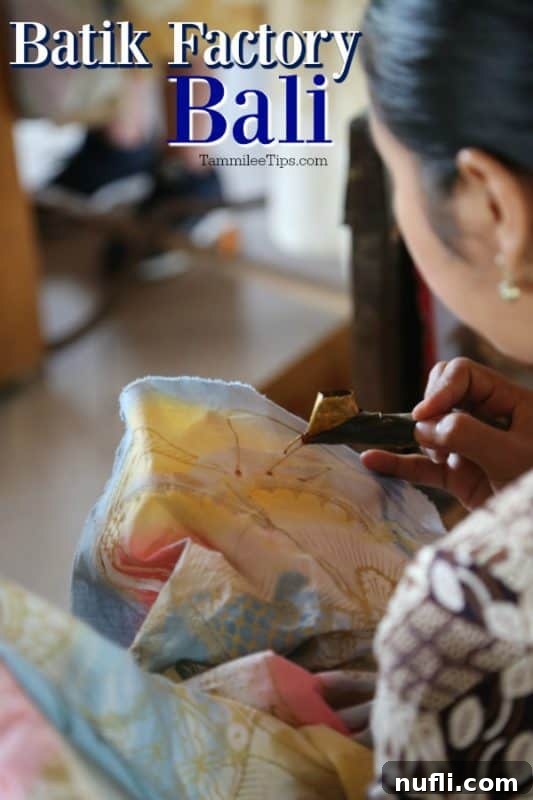 Balinese woman meticulously working on batik fabric, demonstrating the delicate art of wax resist dyeing