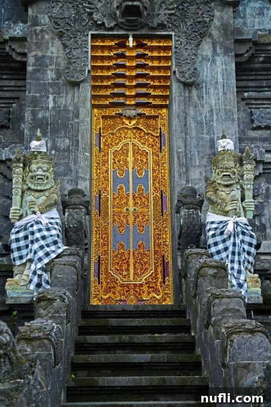 Temple doors with two figurines on either side of the gold doors