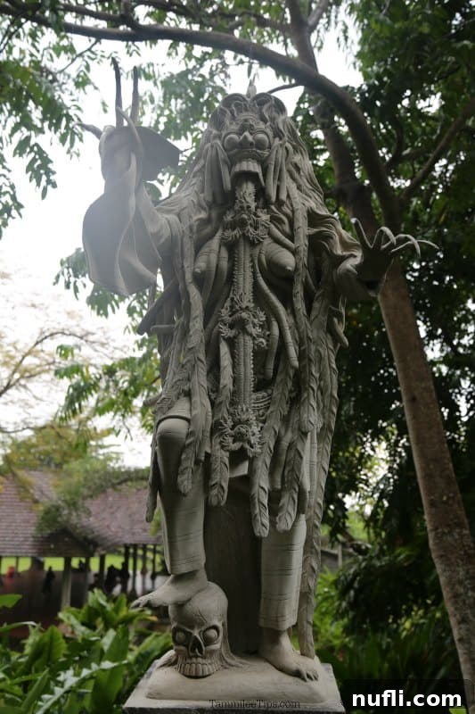 Bali's Tirta Gangga: Royal Water Gardens 6 A unique Balinese statue, possibly a deity or mythical figure, standing prominently on a stylized skull base.