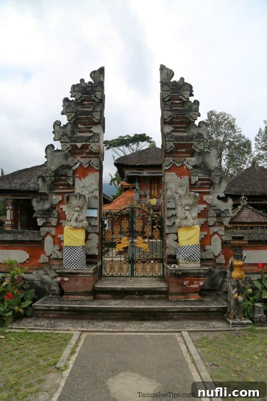 Intricately carved traditional Balinese temple gates at Ulun Danu Beratan, flanked by guardian figures, inviting visitors into the sacred complex