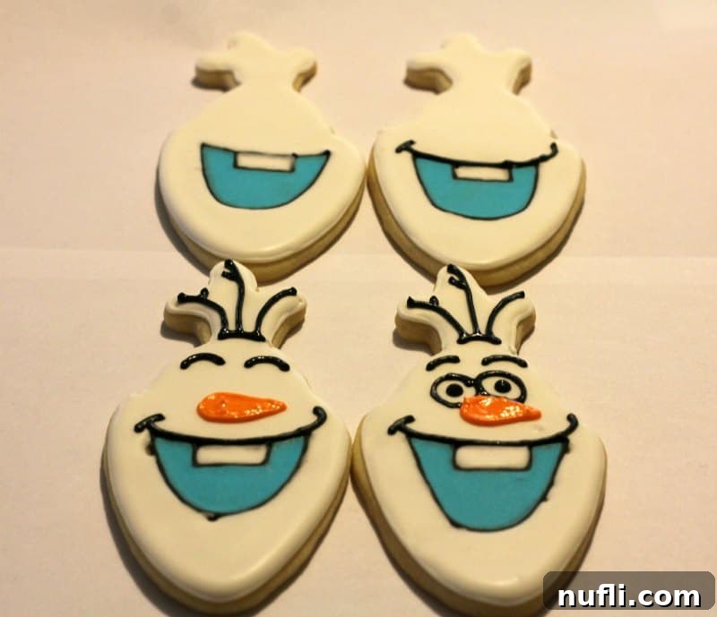 Irresistibly Cute Olaf Cookies 5 Four Olaf cookies displaying different completed decoration stages, from base to final details.