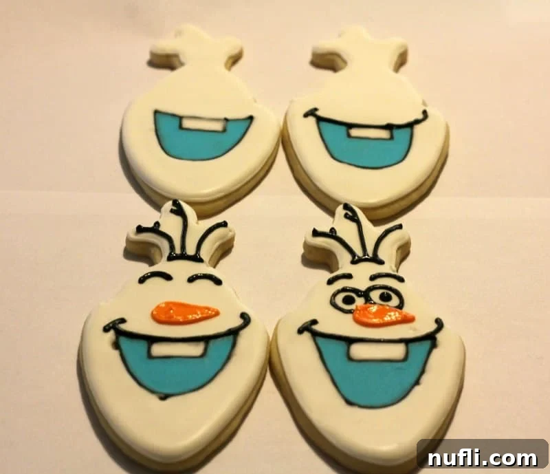 Four Olaf cookies displaying different completed decoration phases, from outline to full detail.
