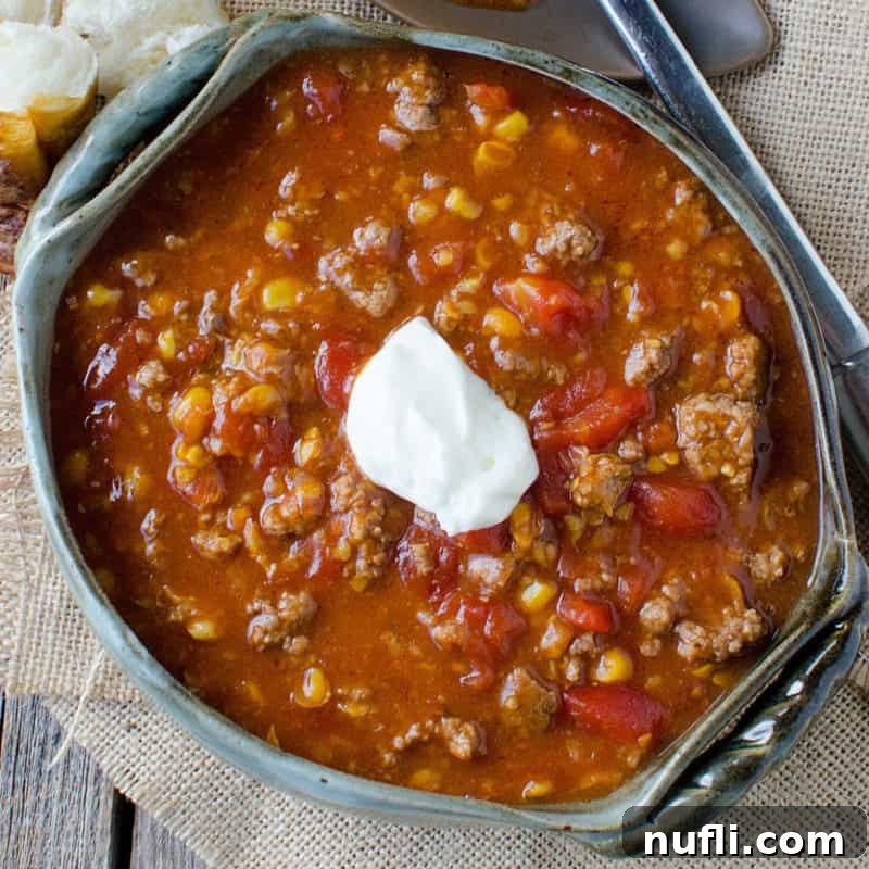 Crock Pot Camp Stew in a dark bowl on a cloth napkin