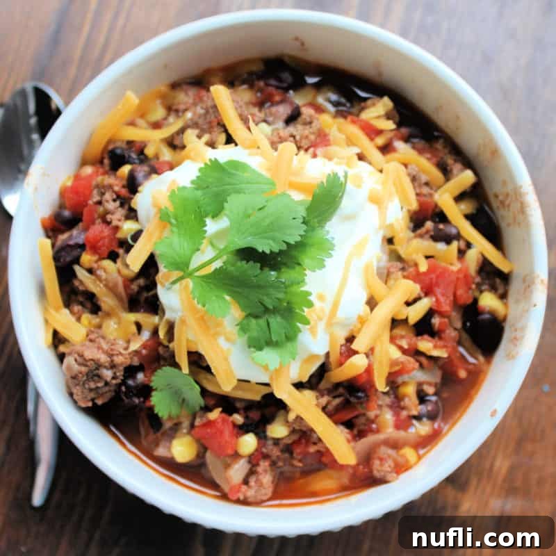 Taco soup garnished with cilantro in a white bowl