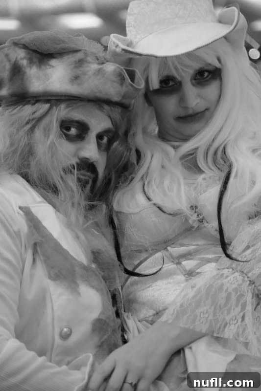 A black and white photograph capturing a couple in intricately designed Halloween costumes, reflecting the creative spirit of a cruise ship Halloween party.