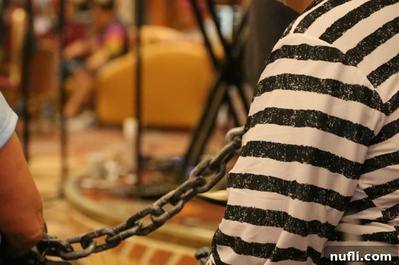 A person in a 'jail' costume, complete with a chain, humorously posed, embodying the playful spirit of Halloween celebrations on a cruise.