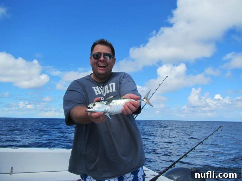 Grand Turk Deep Sea Fishing: Hooking Adventure, Landing Joy 7 John is holding a tuna on a boat