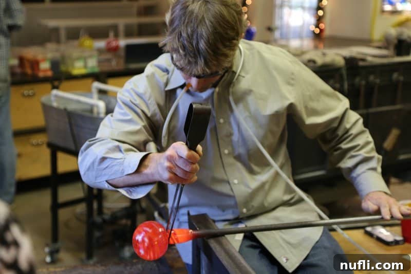 glass worker bloging on a glowing red ball 