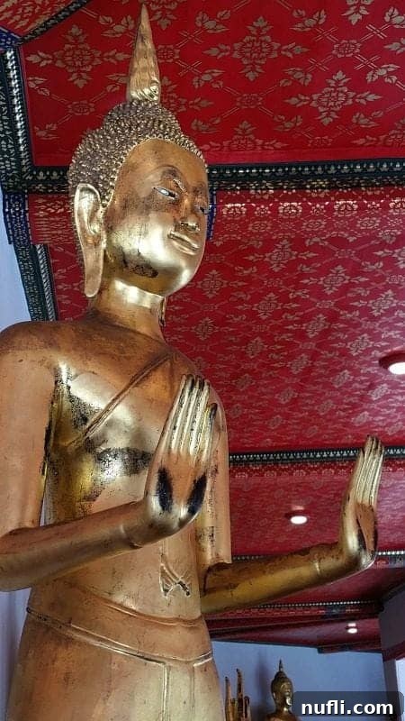 Golden Buddha statue with hands in a meditative pose, representing other diverse Buddha images found within the expansive Wat Pho complex.