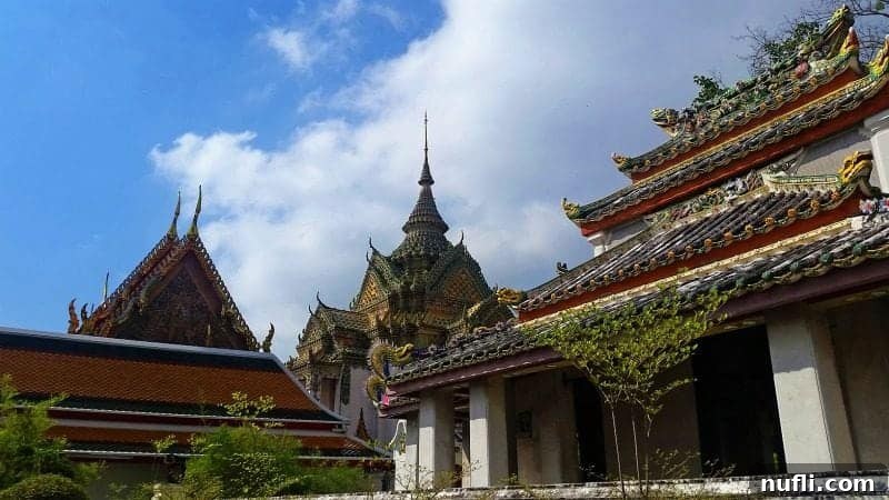 Another view of an ornate temple building showcasing traditional Thai architecture, with gilded elements and colorful tile work at Wat Pho.