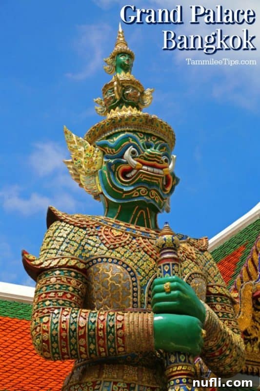 Bangkok's Grand Palace: Discovering Royal Thailand with Essential Visitor Tips 2 Grand Palace Bangkok over green figure with a staff, showcasing its regal architecture