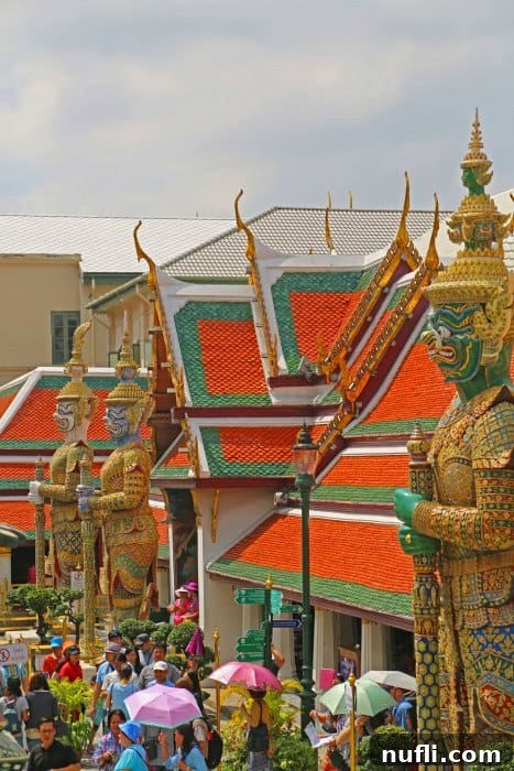 Bangkok's Grand Palace: Discovering Royal Thailand with Essential Visitor Tips 8 Looking over Tall statues over people in the Grand Palace, showing the scale of the complex