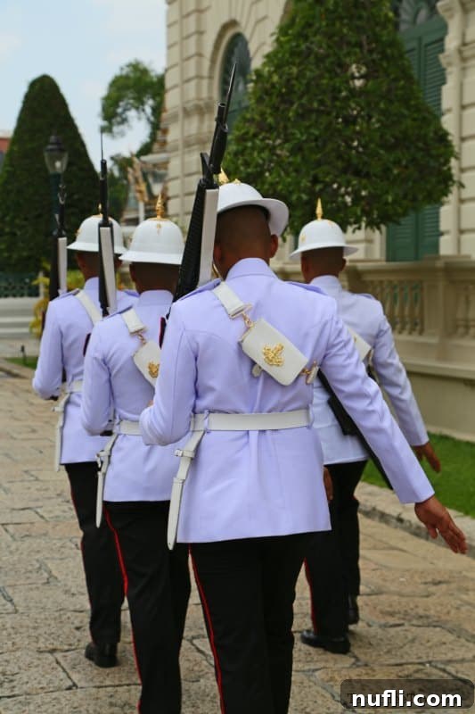 Bangkok's Grand Palace: Discovering Royal Thailand with Essential Visitor Tips 9 Guards carrying guns walking in the Grand Palace, adding to the ceremonial atmosphere