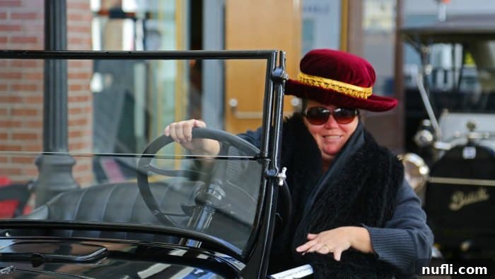 Tammilee in a historic car, posing for a photo op