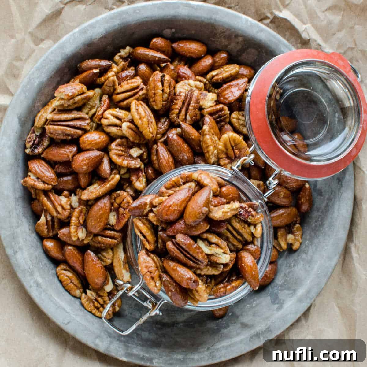 Over 40 Simple Plant-Based Slow Cooker Meals 13 sweet and spicy nuts spread on a silver tray with a glass jar, a crunchy and flavorful snack