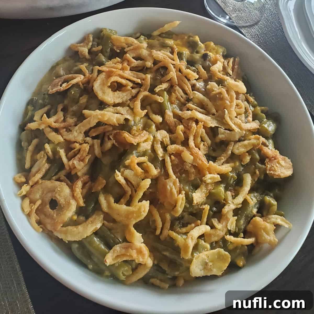 Over 40 Simple Plant-Based Slow Cooker Meals 4 fried onions on top of green beans in a white bowl, a crunchy and creamy side dish