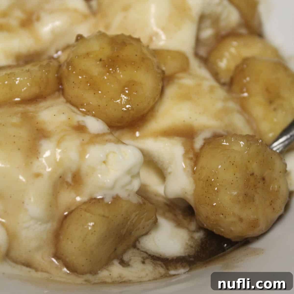 Over 40 Simple Plant-Based Slow Cooker Meals 37 Crock Pot Bananas Foster in a white bowl with vanilla ice cream, a decadent banana dessert