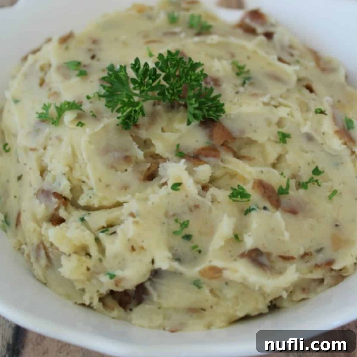 Over 40 Simple Plant-Based Slow Cooker Meals 38 garlic herb mashed potatoes in a white bowl, an aromatic and flavorful holiday side