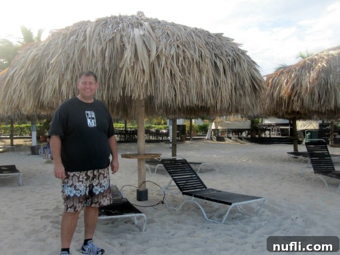 Aruba Cruise Highlights 8 John standing next to a thatched palapa and lounge chairs