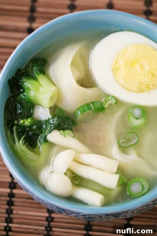 hard boiled egg, mushrooms, and noodles in a blue bowl