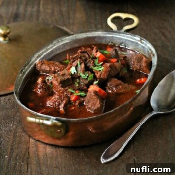 Hungarian Goulash in a metal pan next to a spoon and lid