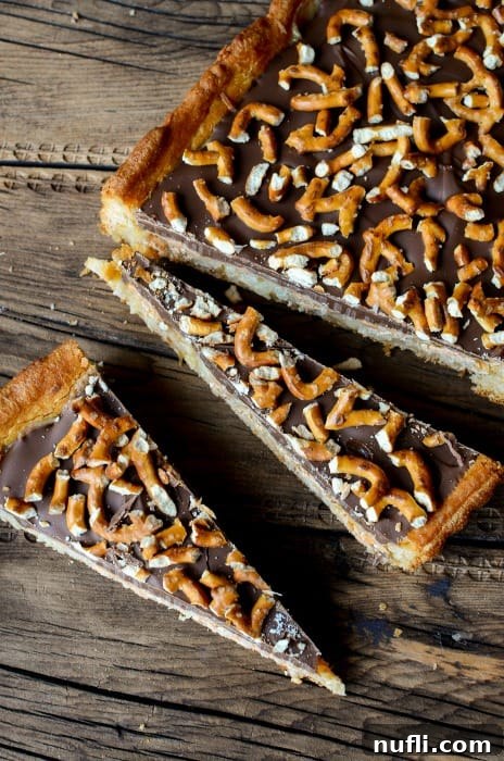 Triangular pieces of chocolate pretzel bars artfully arranged, showcasing their perfect cut and delicious layers of crust, caramel, chocolate, and pretzel topping.