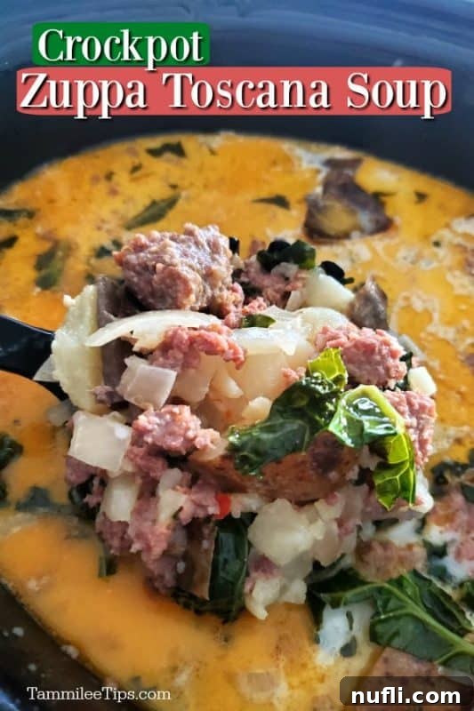 A large spoon lifting a generous serving of Crockpot Zuppa Toscana Soup, showcasing the sausage, potatoes, and kale, from a slow cooker.