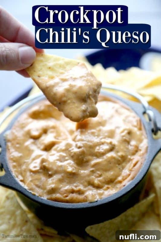 A hand dipping a crispy tortilla chip into a bowl of rich, homemade Chili's copycat queso.
