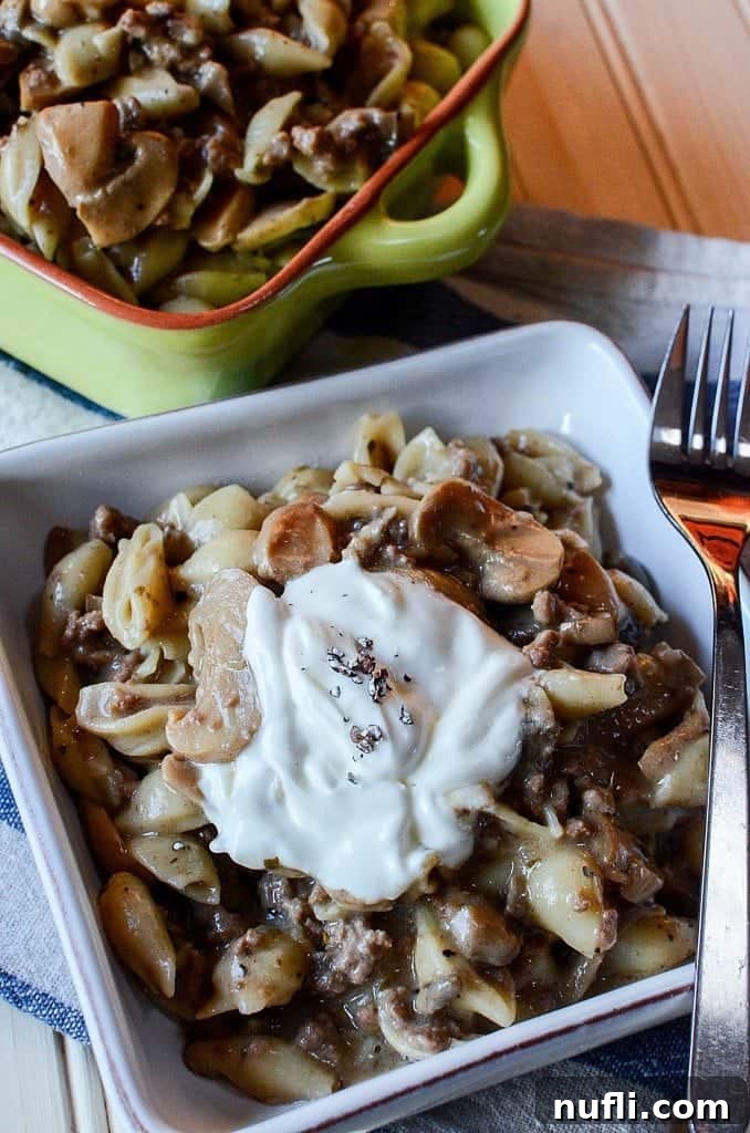 A rich and creamy Crock Pot Mushroom, Ground Beef, and Pasta Casserole, beautifully garnished with fresh herbs and served in a rustic, cozy setting, perfectly highlighting its appeal for family dinners.